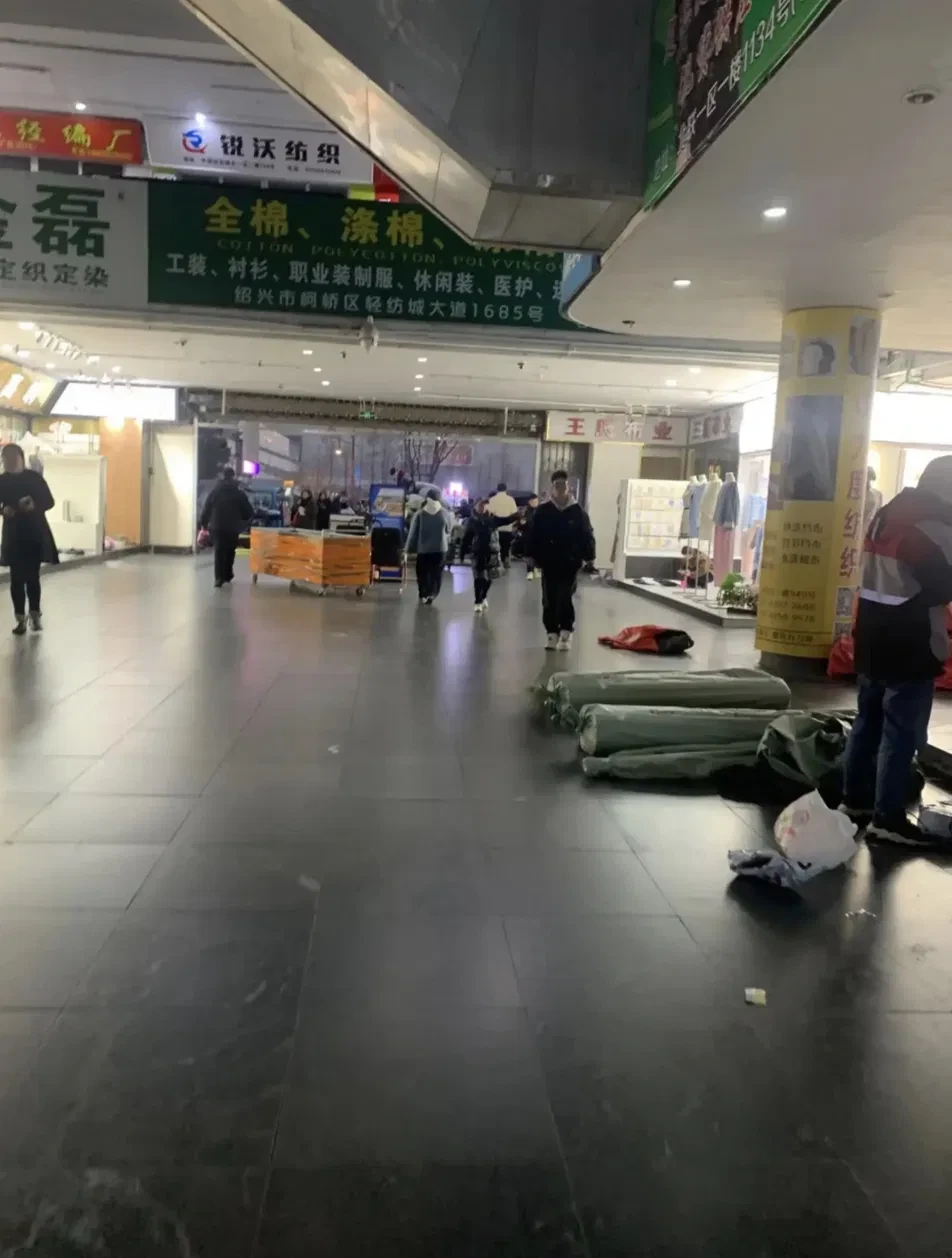 Shaoxing Keqiao textile market in the evening with fabric rolls on the floor
